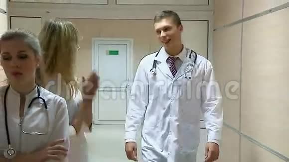 年轻的医生走在医院的走廊上带着所有的问候然后走进他的办公室视频的预览图