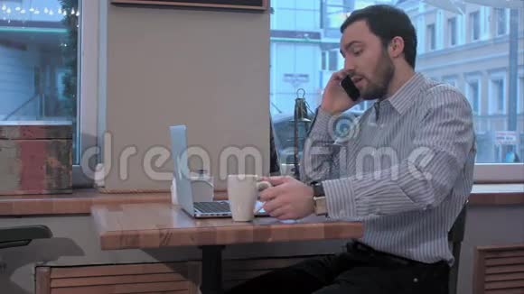 不高兴的商人在咖啡馆打电话视频的预览图