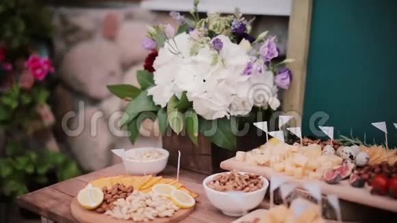奶酪桌和其他小吃花切片奶酪坚果鸡蛋和西红柿在木板上视频的预览图