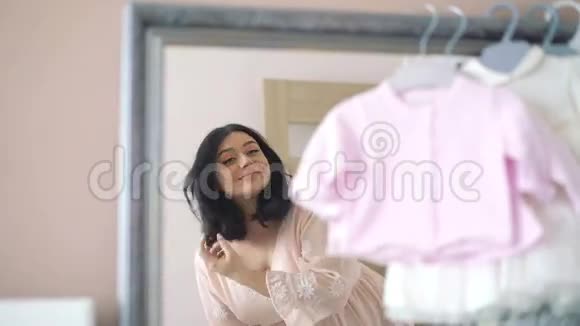 在婴儿房照镜子的漂亮孕妇4k视频的预览图