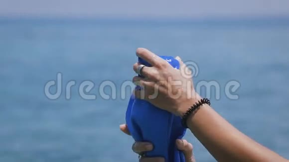 女孩用手捏着一条蓝色毛巾水流下去漂亮的黑色手镯和戒指戴着一个年轻的女人视频的预览图