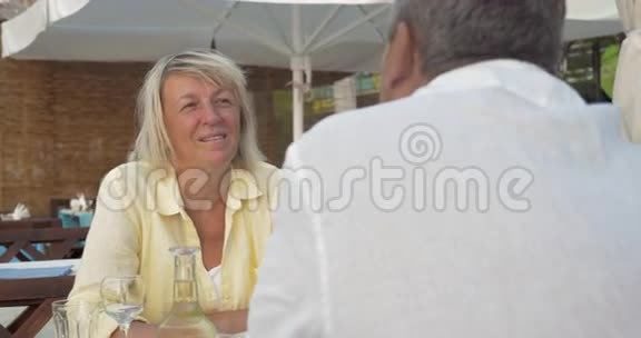 一对老夫妇在夏天的咖啡馆里兴奋地交谈视频的预览图