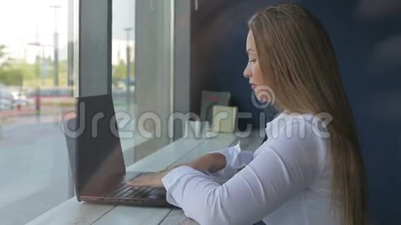 漂亮的女商人用笔记本电脑坐在办公桌前视频的预览图