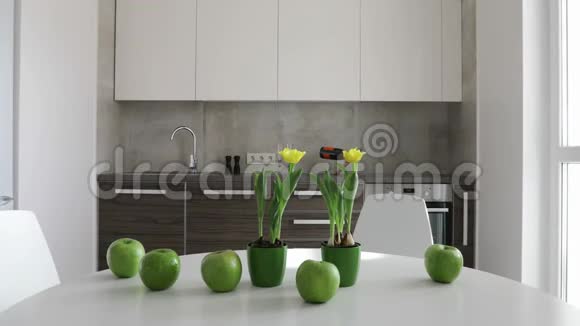 4K斯堪的纳维亚风格的现代厨房内部苹果和鲜花的运动全景视频的预览图