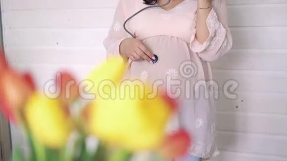 孕妇用听诊器检查白色背景4k视频的预览图