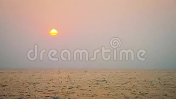 当巨大的太阳落在海洋上方的地平线上时橙色的日落视频的预览图