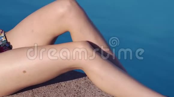 漂亮的女人躺在游泳池附近迷人的晒黑女孩躺在泳池边视频的预览图