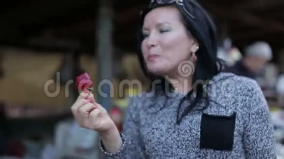 快乐晒黑的女人吃成熟多汁的草莓视频的预览图