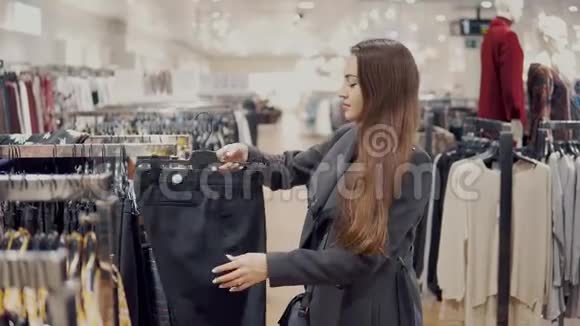 年轻漂亮的女人在商店超市里发现自己的新衣服视频的预览图