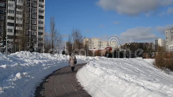 女人正沿着俄罗斯莫斯科的林荫大道走着视频的预览图