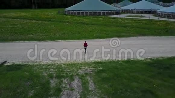 无人驾驶飞机跟踪一个女孩的鸟瞰乡村无人驾驶飞机顶部视图4K超高清视频视频的预览图