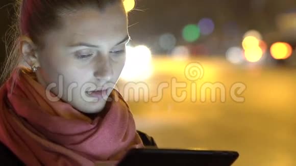 晚上用平板电脑关门女孩站在街上慢慢地视频的预览图