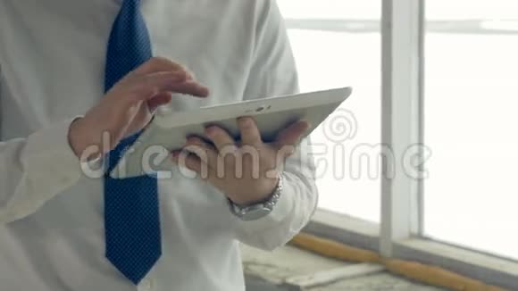 商人手里的平板电脑在一个建筑工地里打滑头视频的预览图