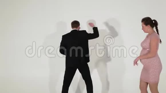 穿着黑色衬衫的可爱男性和怀孕女性在灯光室跳舞视频的预览图