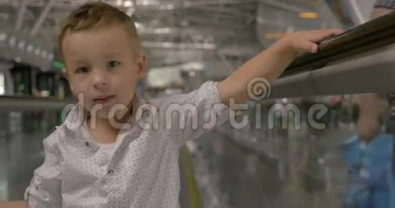 小孩骑在自动扶梯上摆姿势视频的预览图
