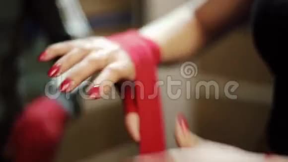 年轻的女孩子用一条红色的弹性绷带包裹她的手臂双手合拢视频的预览图