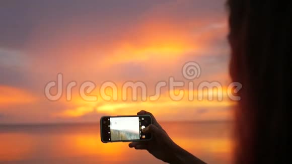 年轻混血女孩用手机拍摄美丽的日落高清慢速运动泰国视频的预览图
