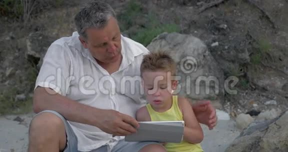 孙子和爷爷带触摸垫户外视频的预览图