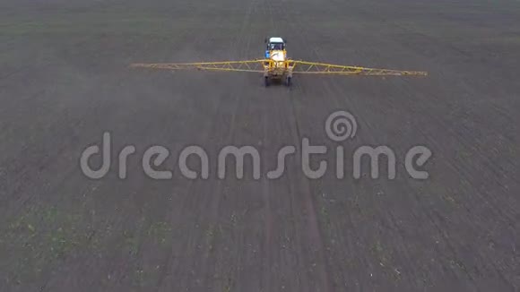 一辆拖拉机骑过田野喷洒庄稼从空中射击视频的预览图