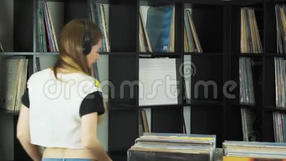 漂亮的年轻女人在乙烯基商店浏览复古唱片视频的预览图