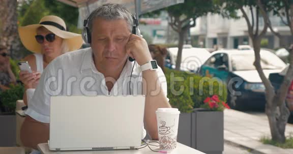 戴耳机的男子在户外咖啡厅聊天视频的预览图