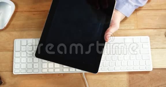 在办公桌上使用数字平板电脑的女商人手桌上有键盘和鼠标视频的预览图