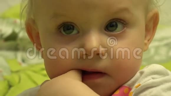 令人惊讶的婴儿咀嚼和咬她是手指特写镜头4K超高清超高清视频的预览图