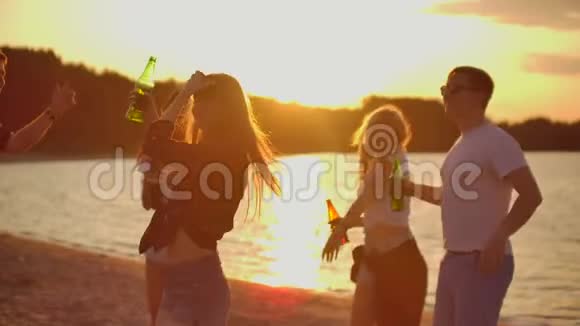 这位年轻的女性正在海滩上日落时跳舞视频的预览图