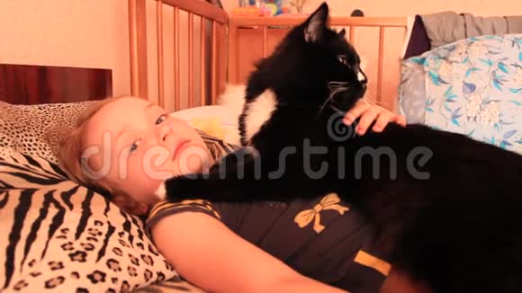 小女孩和她的猫一起躺在床上与你的宠物一起视频的预览图