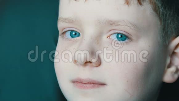 青绿色的眼睛年轻的金发男孩脸上长着红雀斑长长的白色睫毛视频的预览图