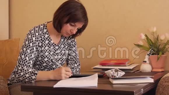 女人在笔记本上用圆珠笔写手写文字视频的预览图