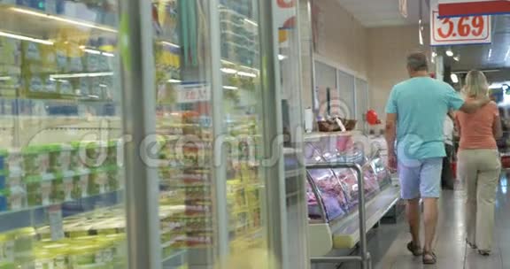 一对夫妇在超市的冰箱里散步视频的预览图