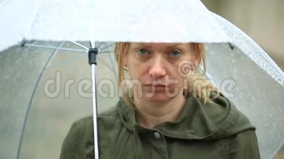 受天气影响雨中伞下站立不快乐的女人视频的预览图