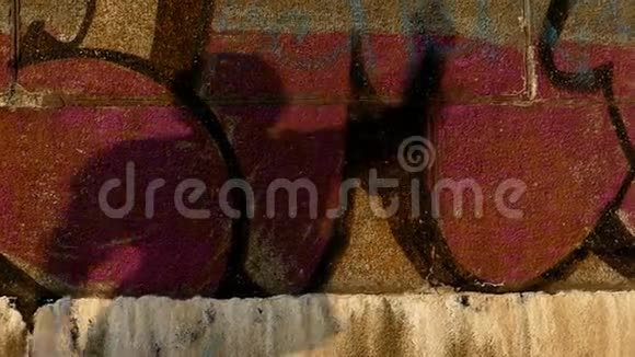 斯隆莫中太阳落山涂鸦墙上男人移动的影子视频的预览图