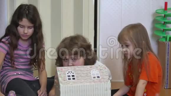 可爱的小女孩玩一只手孩子们做了一个纸盒娃娃屋视频的预览图