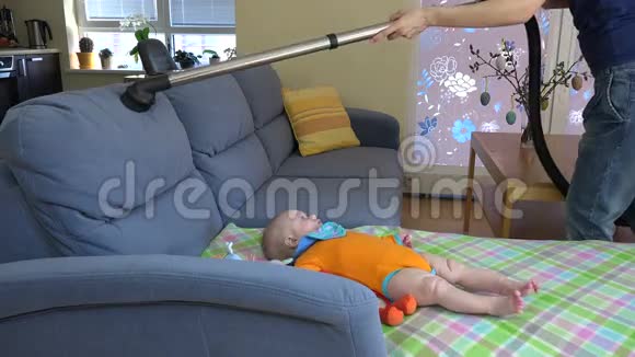 女人把婴儿女儿周围沙发上的灰尘4K视频的预览图