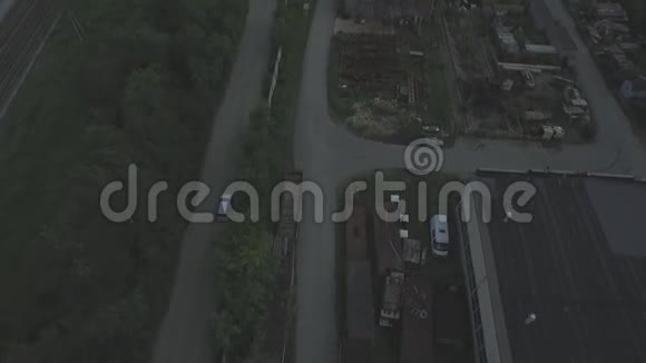 汽车行驶在出城的道路上鸟瞰春天阳光明媚的一天汽车在围栏建筑工地附近公路上行驶视频的预览图