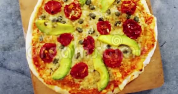 烤披萨加牛油果樱桃番茄和橄榄配料视频的预览图
