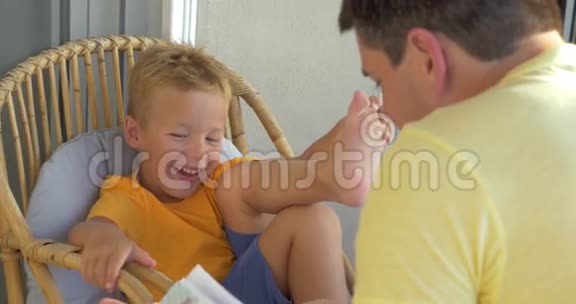 微笑男孩倾听父亲读书视频的预览图