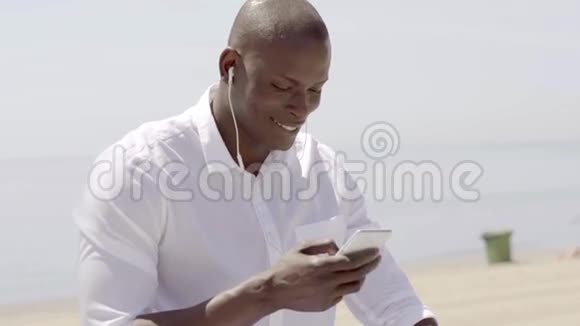 坐着的时候男人用手机听音乐视频的预览图