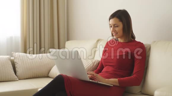 漂亮的年轻女人在酒店房间里用笔记本电脑视频的预览图