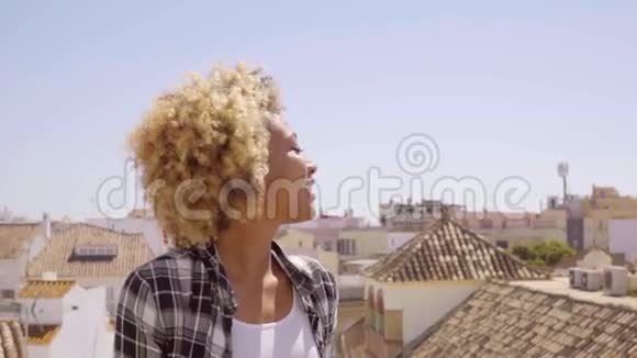 风和日丽的城市屋顶上的年轻女子视频的预览图