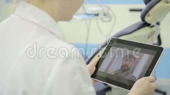 资深病人视频聊天与牙医在个人电脑平板电脑网上医疗咨询视频的预览图