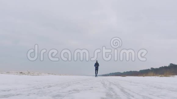 一个男人在雪地海滩上奔跑视频的预览图