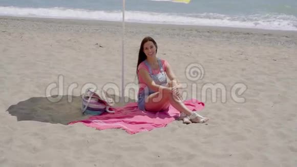 单身女人在海滩伞下放松视频的预览图