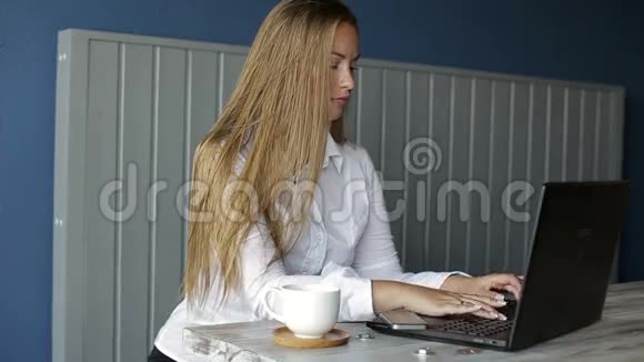 漂亮的女商人用笔记本电脑坐在办公桌前视频的预览图