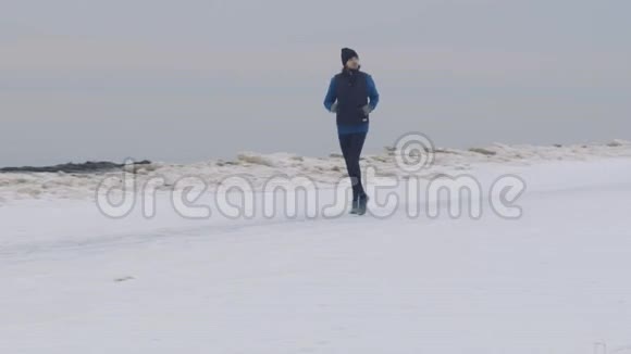 一个男人在雪地海滩上奔跑视频的预览图