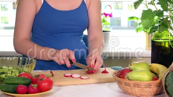 孕妇在砧板上切萝卜蔬菜视频的预览图