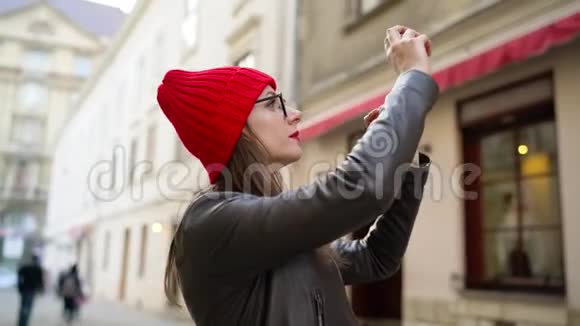女人用智能手机拍摄古城的景点然后沿着中世纪的街道漫步视频的预览图