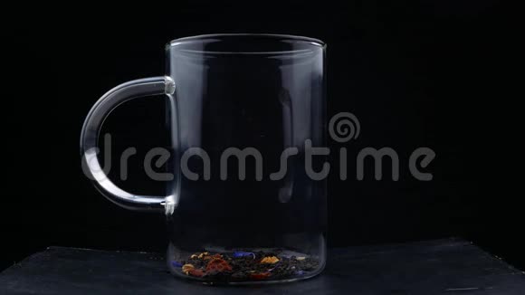 玻璃杯中茶叶中倒入开水的宏观镜头冲泡红茶宏观拍摄的过程视频的预览图